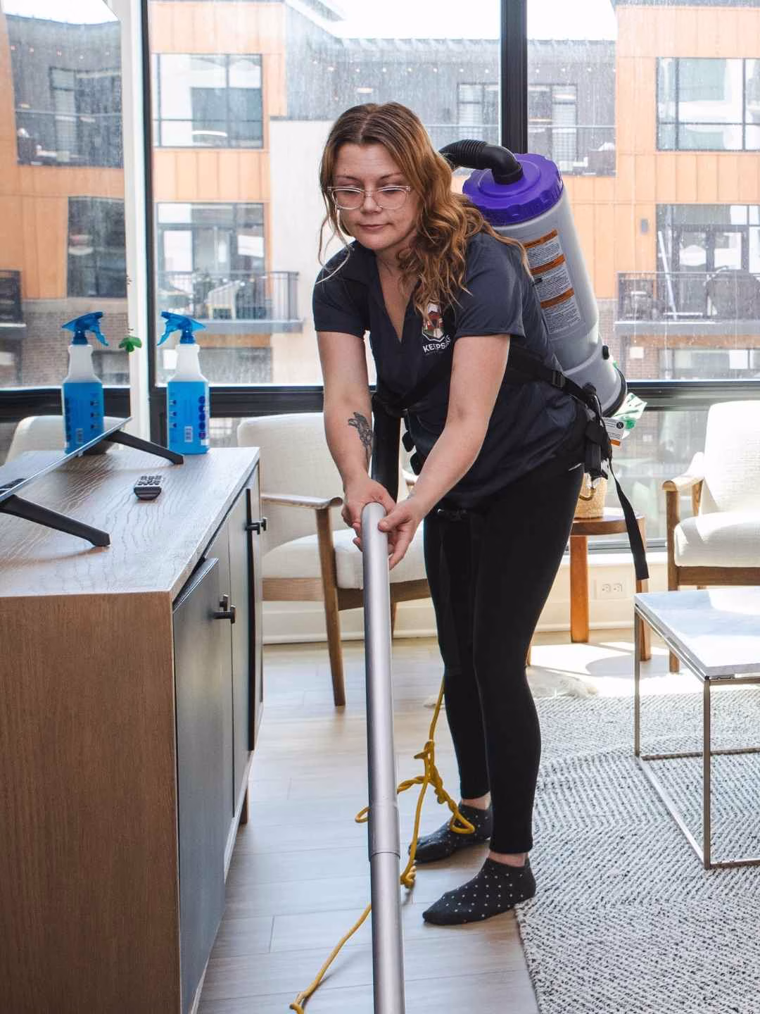 A Keepsake cleaning technician vacuuming an apartment living room in St. Paul, MN