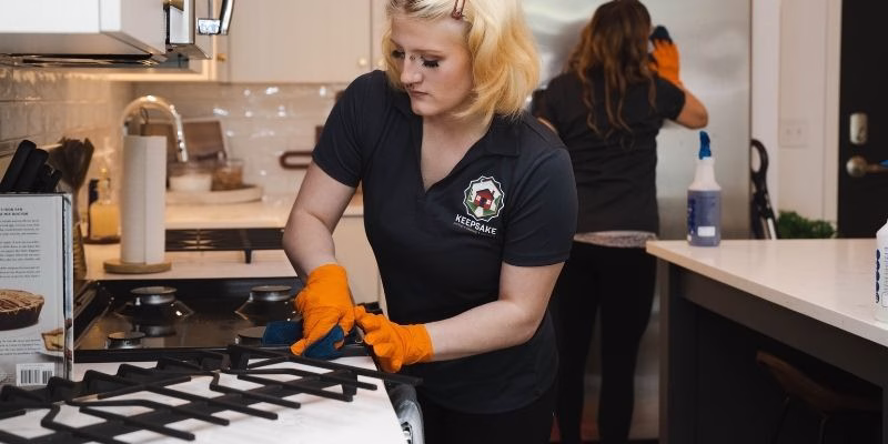 Two Keepsake employees thoroughly cleaning a kitchen as part of a move-in / move-out cleaning service.