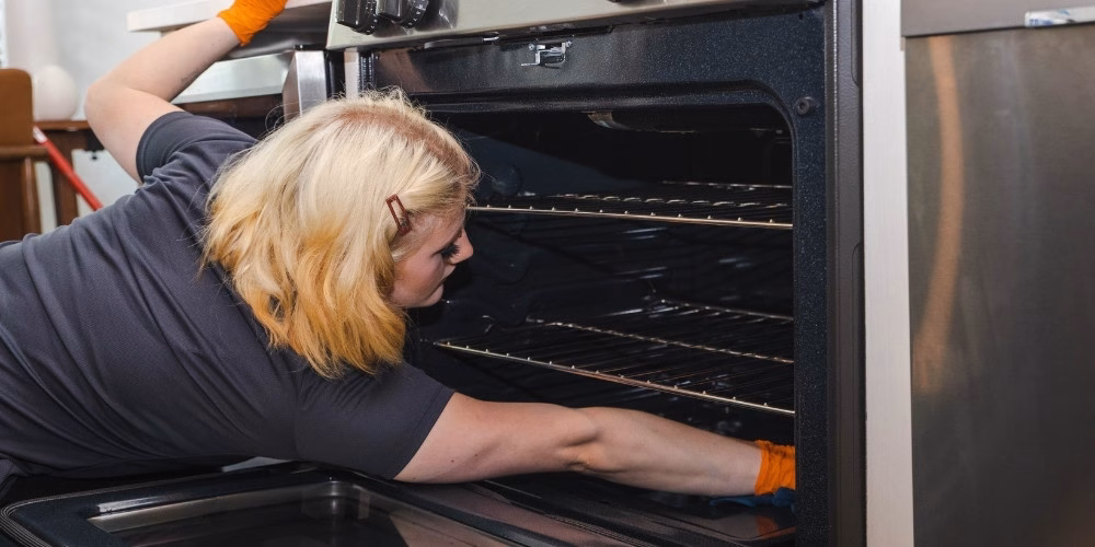 A Keepsake employee cleaning the inside of an oven at a home in the Twin Cities, MN.