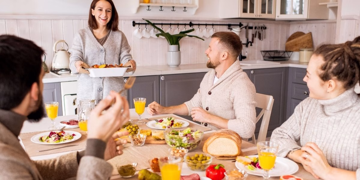 Friends enjoying a meal inside a bright, clean kitchen