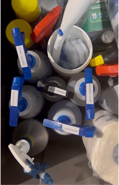 Various cleaning products and tools in a professional cleaning cart
